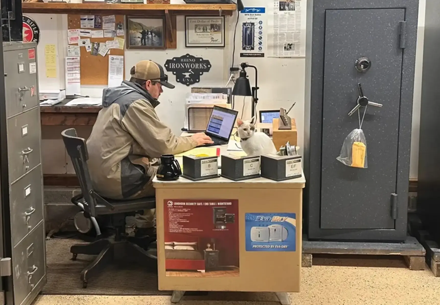 A man sitting at his desk working on a laptop.