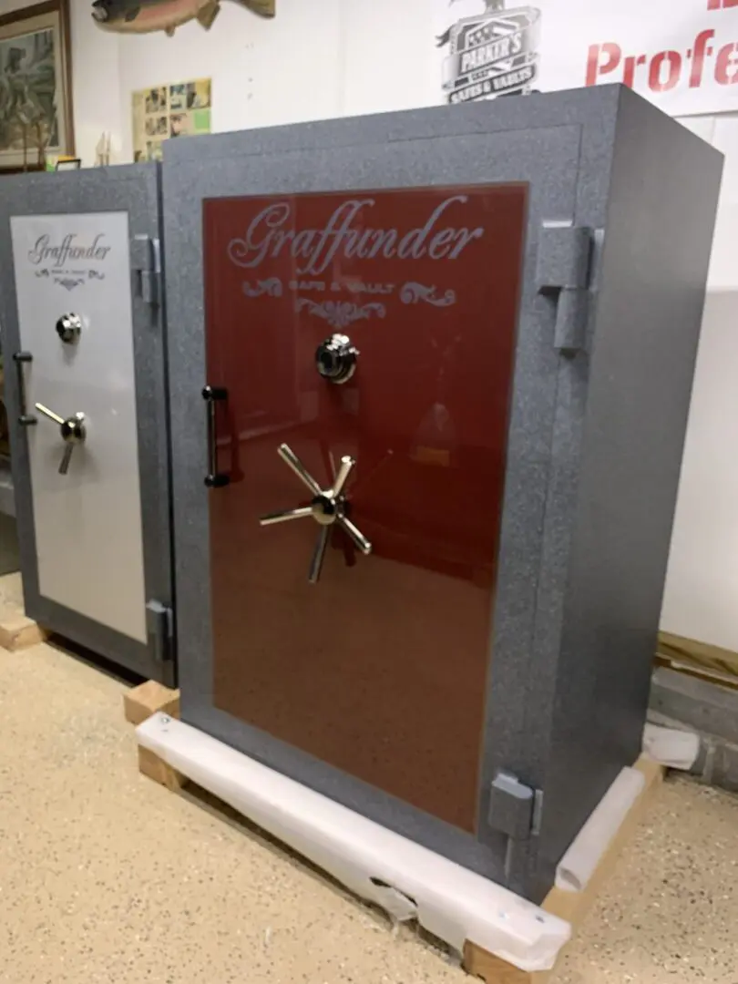 A large red and gray safe sitting on top of a floor.