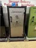 A metal safe sitting on top of a wooden shelf.