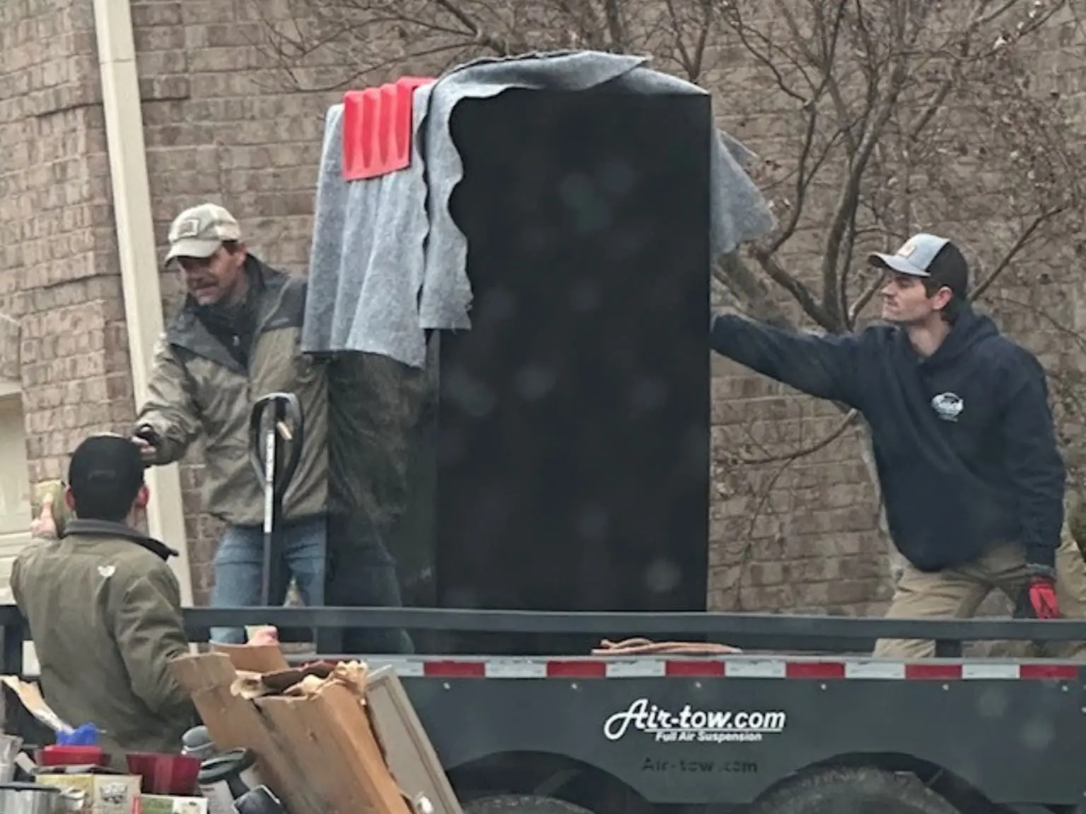 A group of men unloading furniture from the back of a truck.