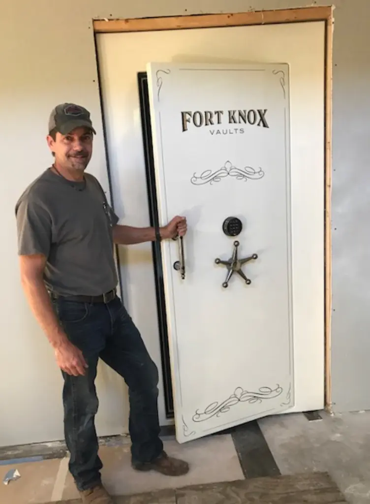 A man standing next to a white door.