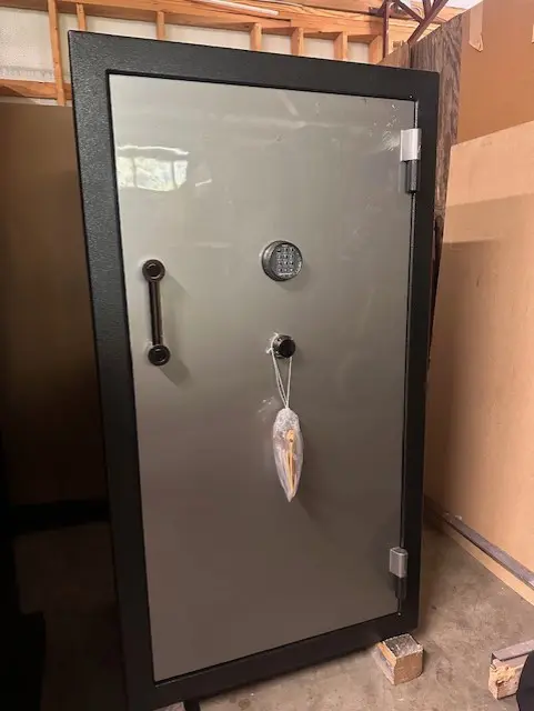 A large metal safe in the corner of a room.