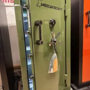 A green safe with keys hanging on the door.